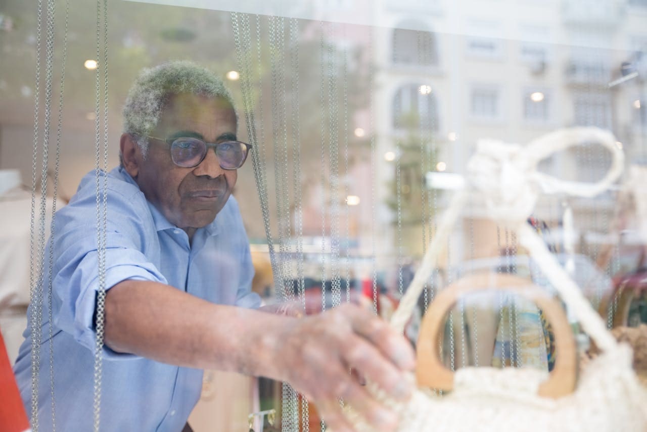 Creative Storefront Strategies to Boost Customer Traffic Man Putting a Bag on the Window Display in a Store